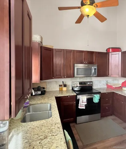 a kitchen with kitchen island granite countertop a sink counter top space appliances and cabinets