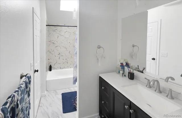 a bathroom with a tub sink and mirror