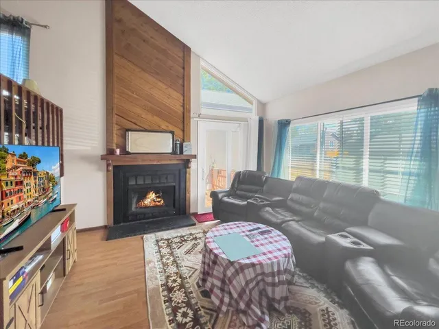 a living room with furniture a fireplace and a large window