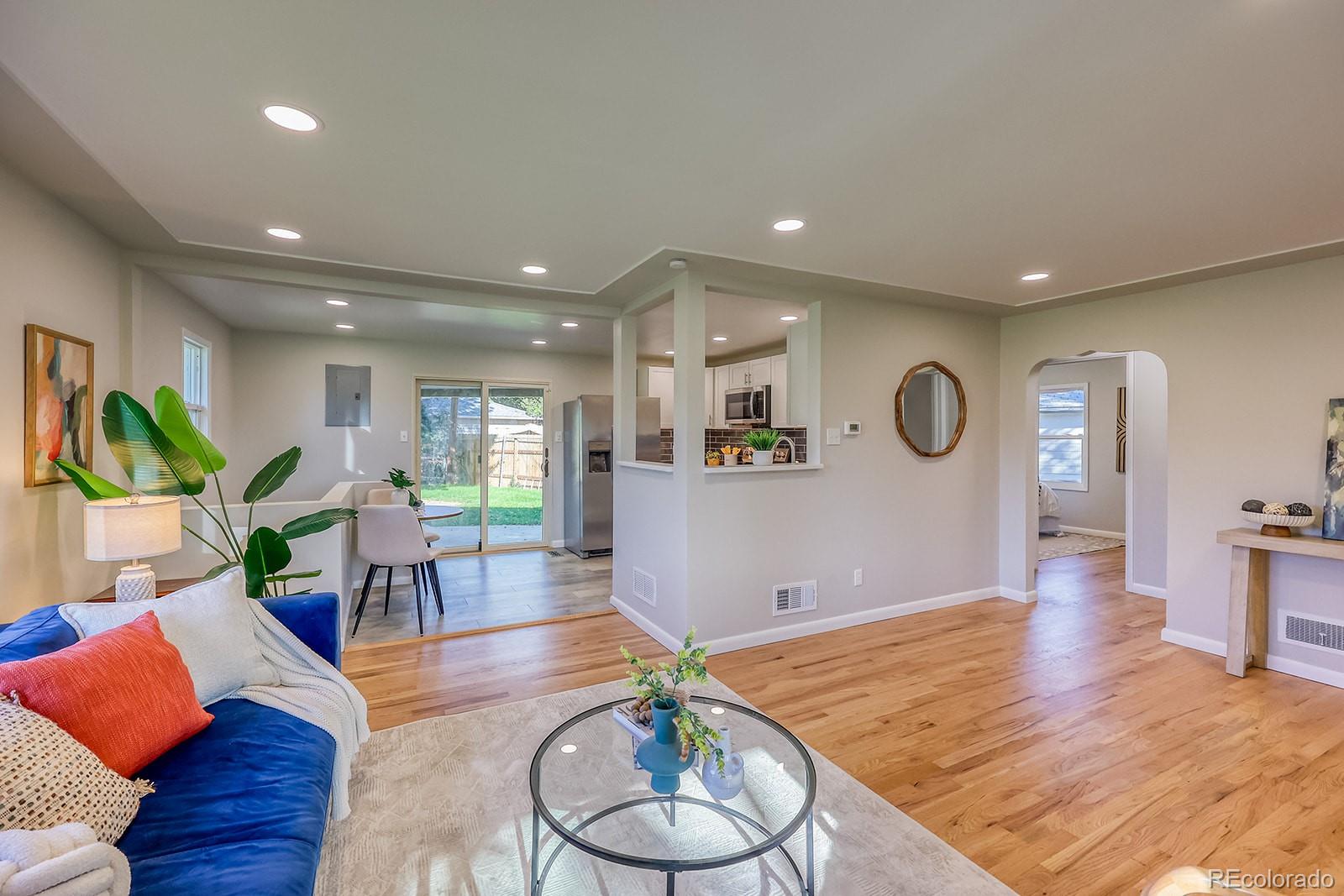 2785 South Hazel Court Denver, CO 80236 - Photo 1 of 38 a living room with furniture kitchen view and a wooden floor