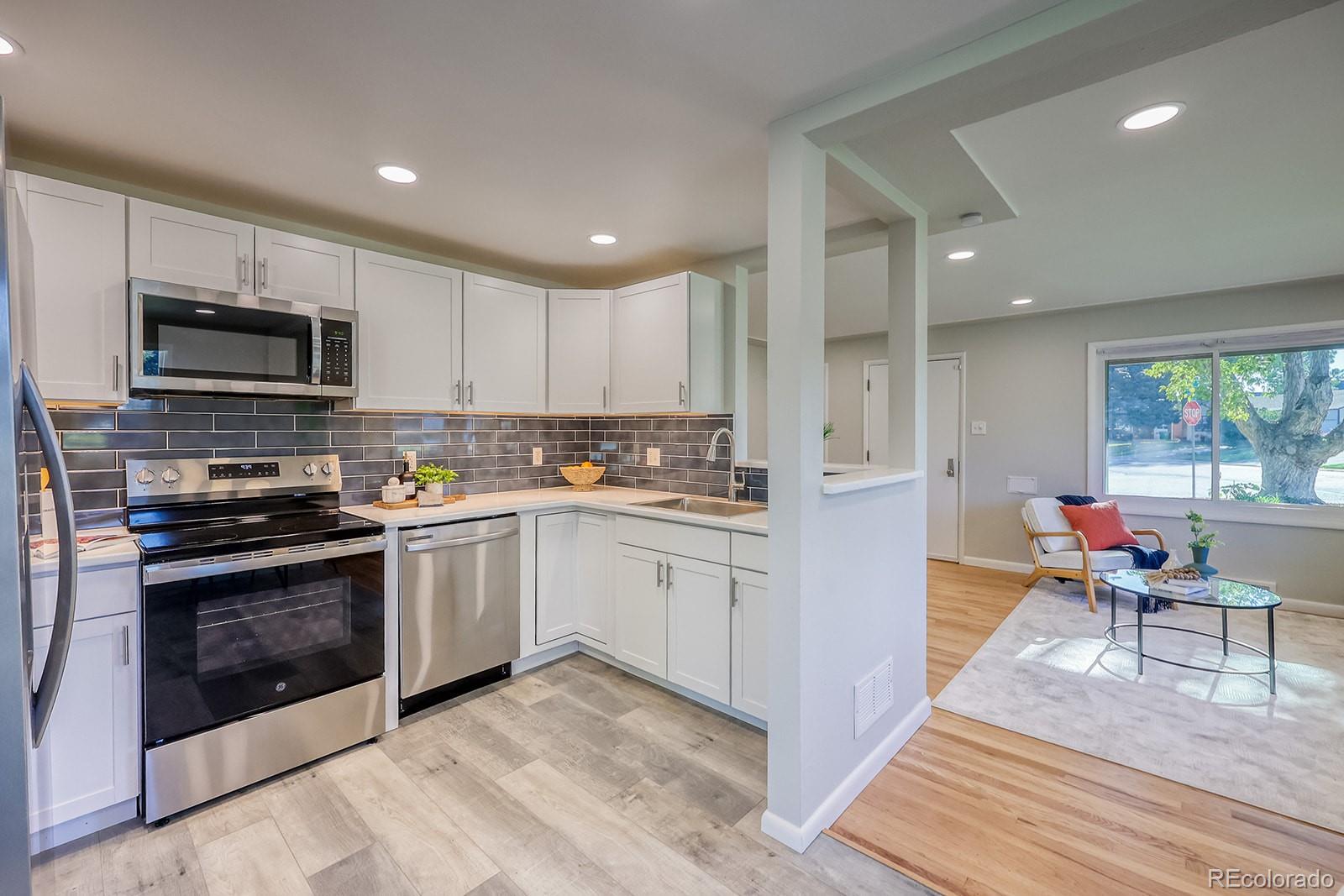 2785 South Hazel Court Denver, CO 80236 - Photo 11 of 38 a kitchen with a sink cabinets and stainless steel appliances