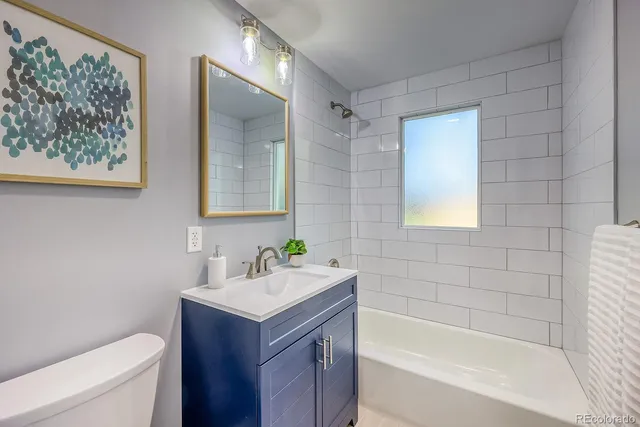 a bathroom with a sink mirror vanity and toilet