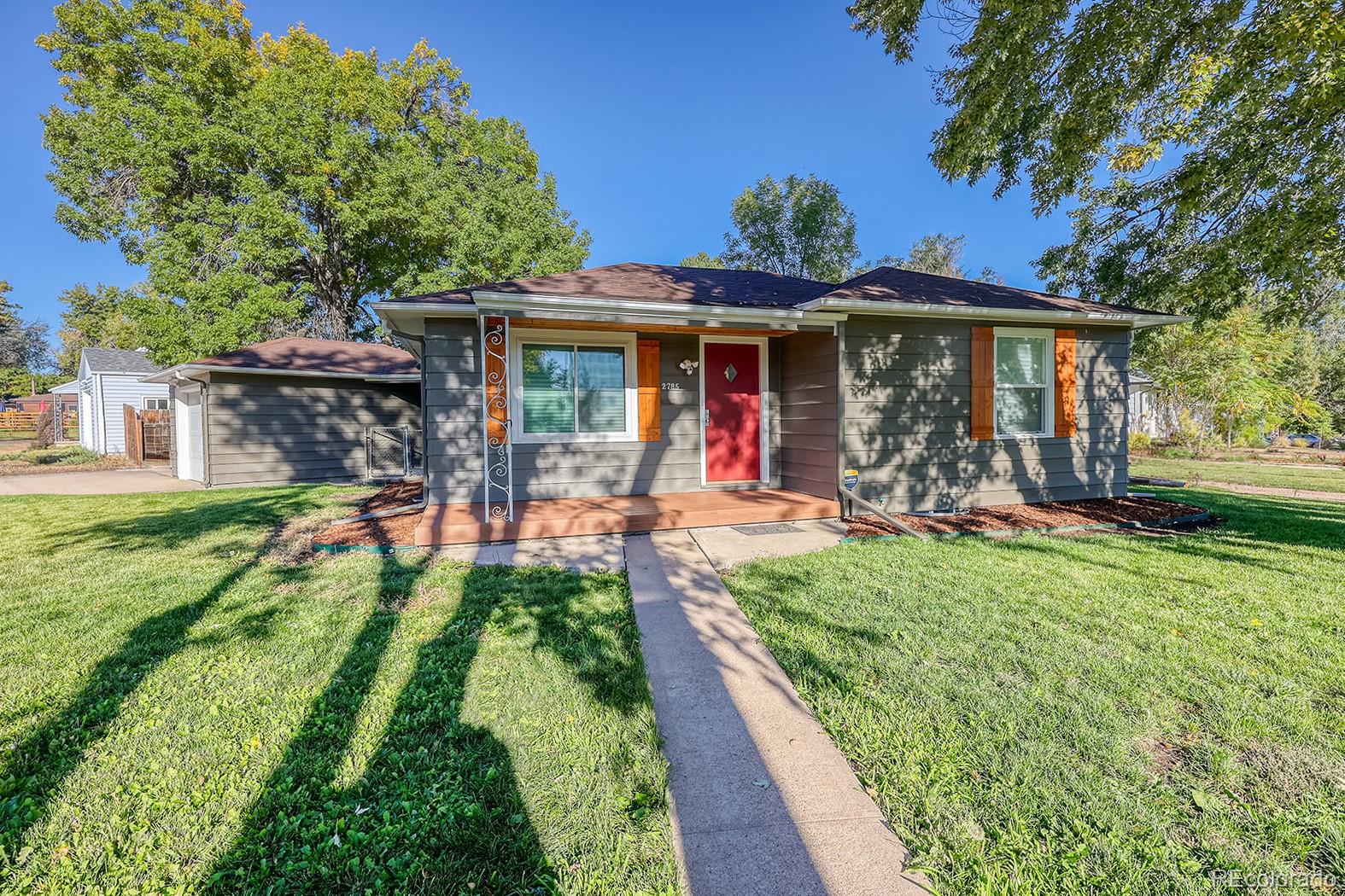 2785 South Hazel Court Denver, CO 80236 - Photo 2 of 38 a front view of a house with garden
