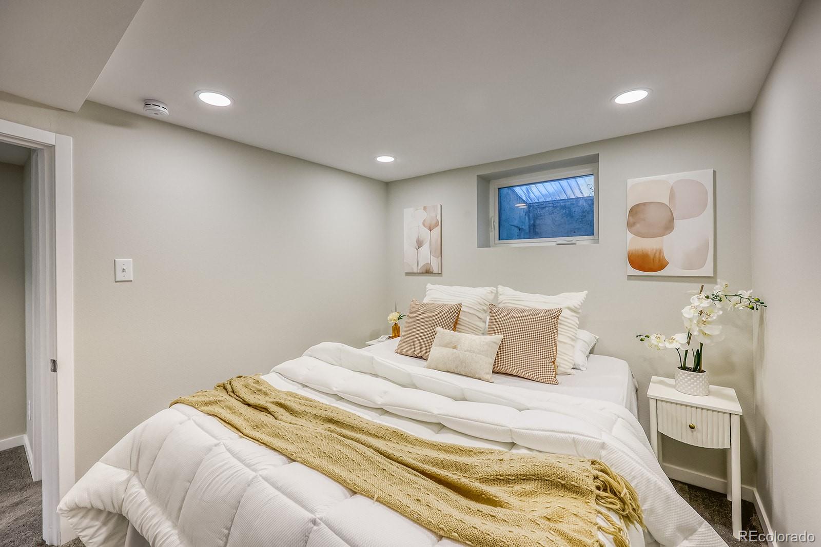 2785 South Hazel Court Denver, CO 80236 - Photo 30 of 38 a bedroom with a bed and lamp