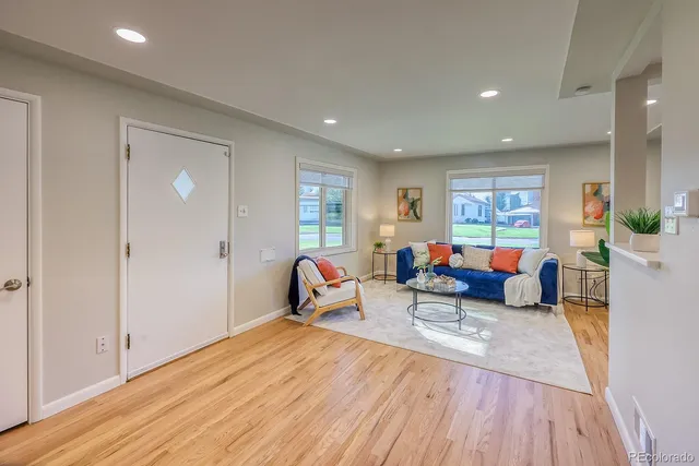 a living room with furniture and a wooden floor