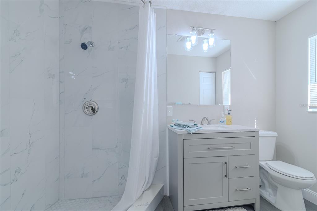 5334 Northwest 19th Place Ocala, FL 34482 - Photo 18 of 42 a bathroom with a toilet sink vanity and mirror