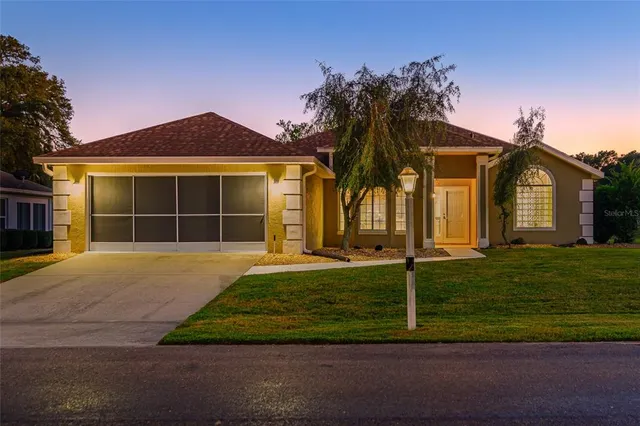 a view of a swimming pool with lawn chairs under an umbrella