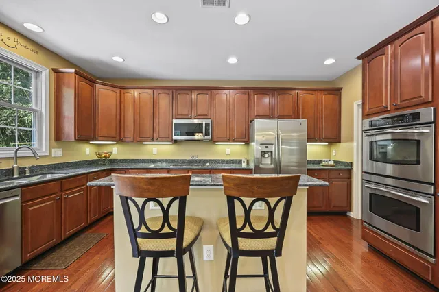 a kitchen with stainless steel appliances granite countertop a sink stove and refrigerator