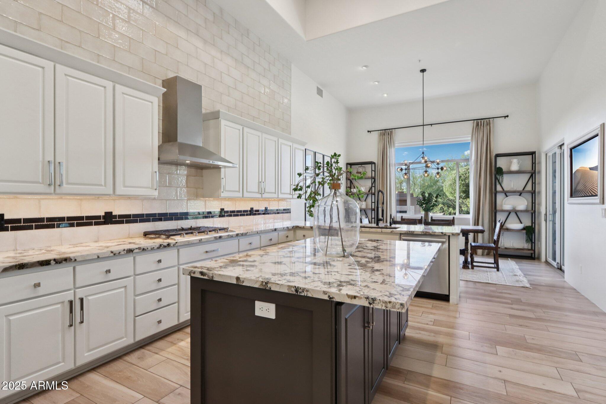 30600 North Pima Road, Unit 49 Scottsdale, AZ 85266 - Photo 13 of 53 a kitchen with kitchen island granite countertop a sink cabinets and wooden floor