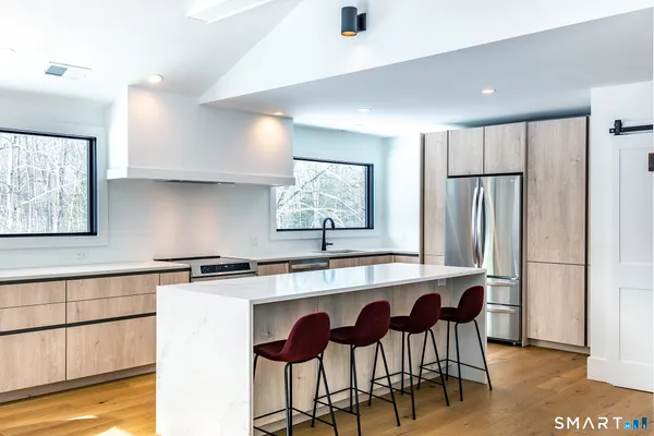a kitchen with stainless steel appliances granite countertop a sink and a refrigerator