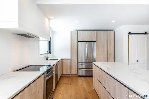 a kitchen with granite countertop a refrigerator and a sink