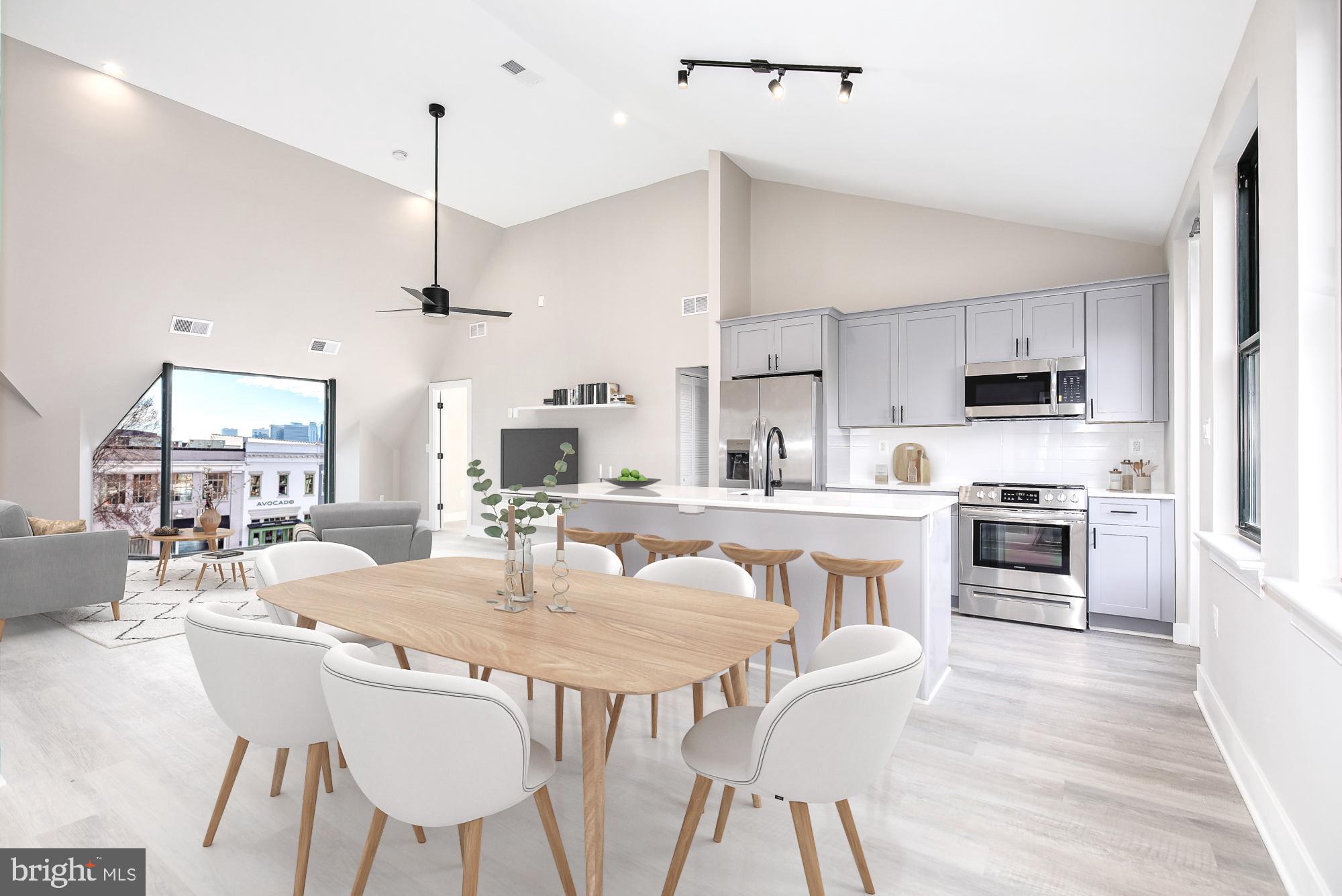 a kitchen with stainless steel appliances kitchen island granite countertop a kitchen island a stove a table and chairs