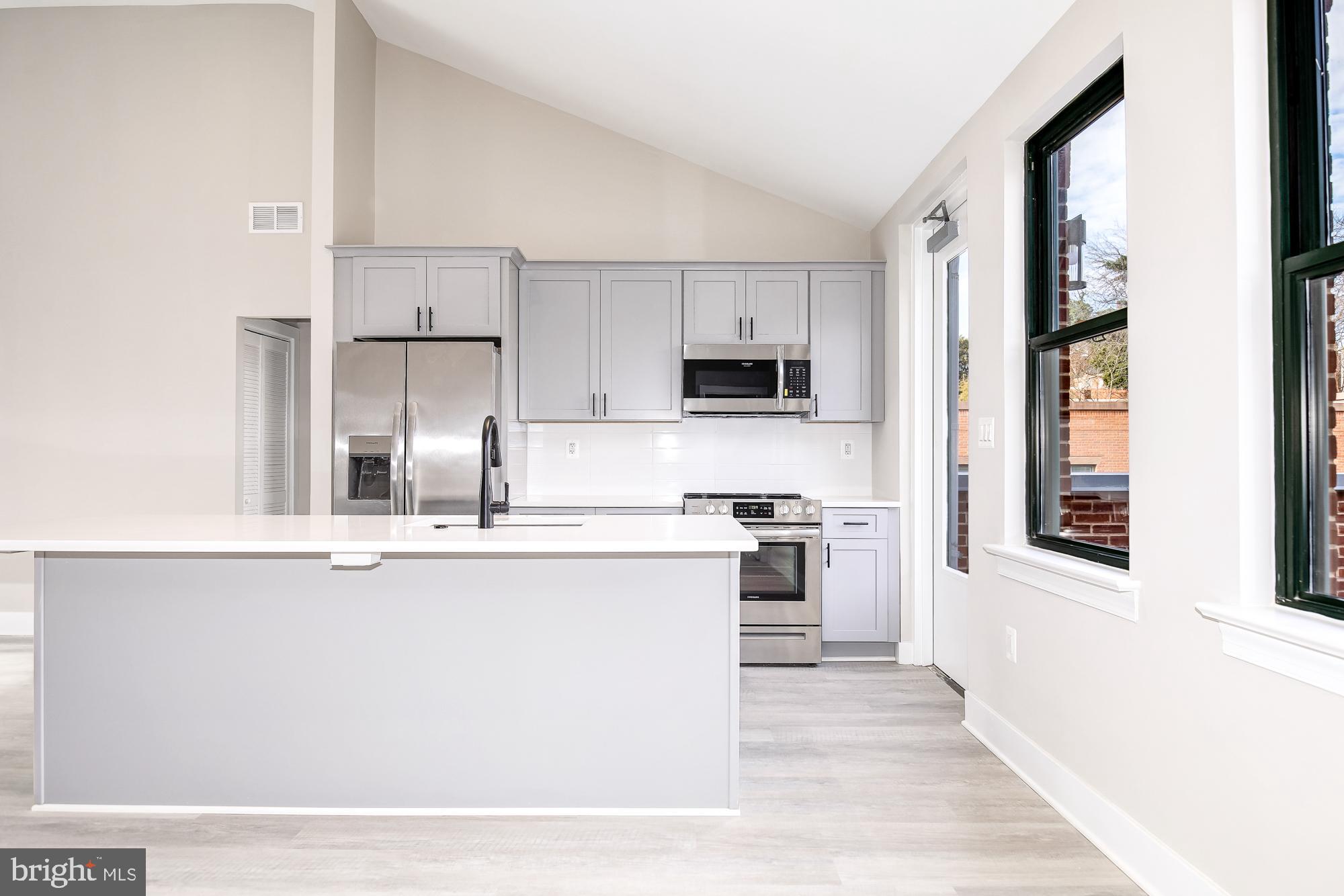 3325 M Street Northwest, Unit TWO Washington, DC 20007 - Photo 3 of 33 a kitchen with stainless steel appliances granite countertop a stove a sink dishwasher and a refrigerator