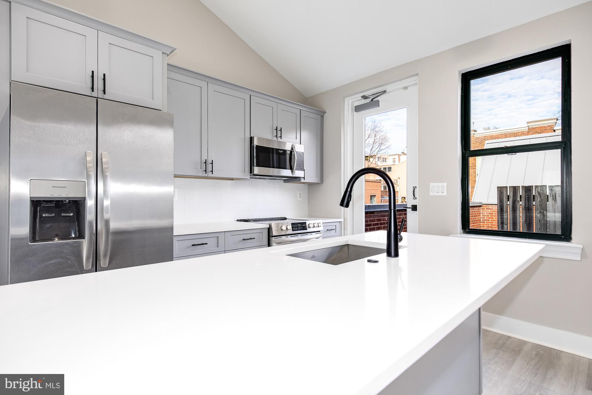 3325 M Street Northwest, Unit TWO Washington, DC 20007 - Photo 5 of 33 a kitchen with stainless steel appliances a sink microwave and refrigerator