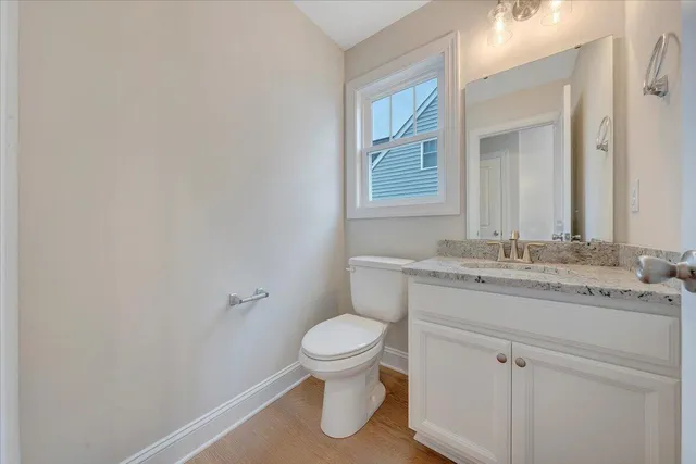 a bathroom with a granite countertop sink a toilet and a mirror