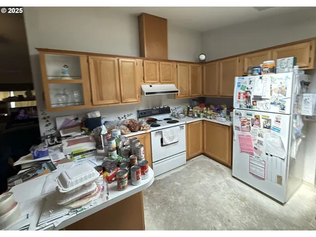 a kitchen with stainless steel appliances granite countertop a stove refrigerator and cabinets