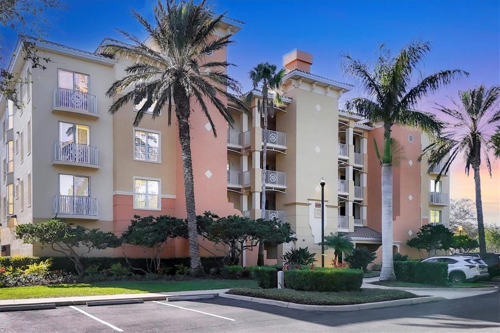 6450 Water Crest Way, Unit 202 Lakewood Ranch, FL 34202 - Photo 1 of 1 a front view of multi story residential apartment building with yard and green space