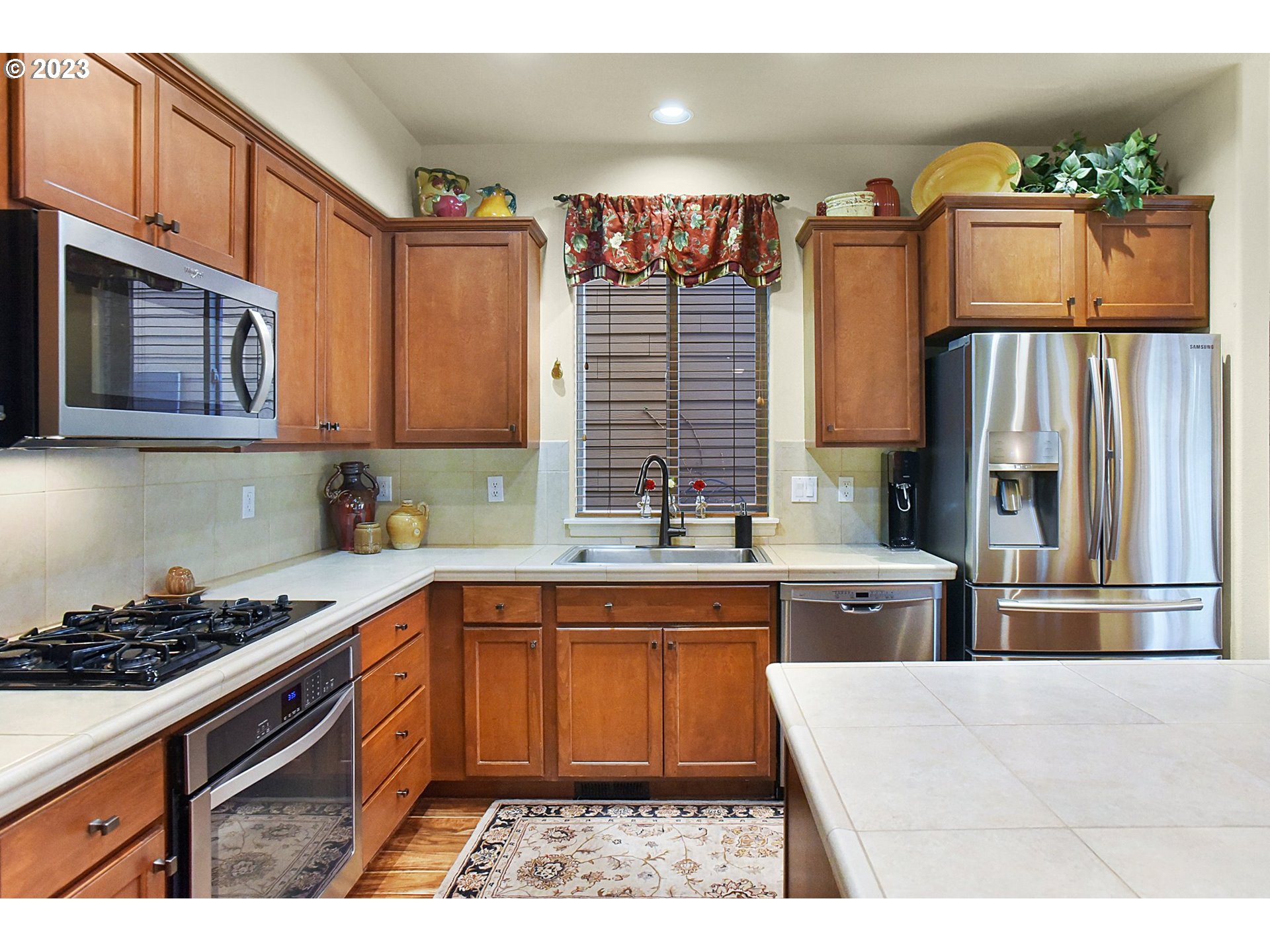 7826 Southwest Alder Street Tigard, OR 97224 - Photo 11 of 30 a kitchen with stainless steel appliances kitchen island granite countertop a refrigerator and stove