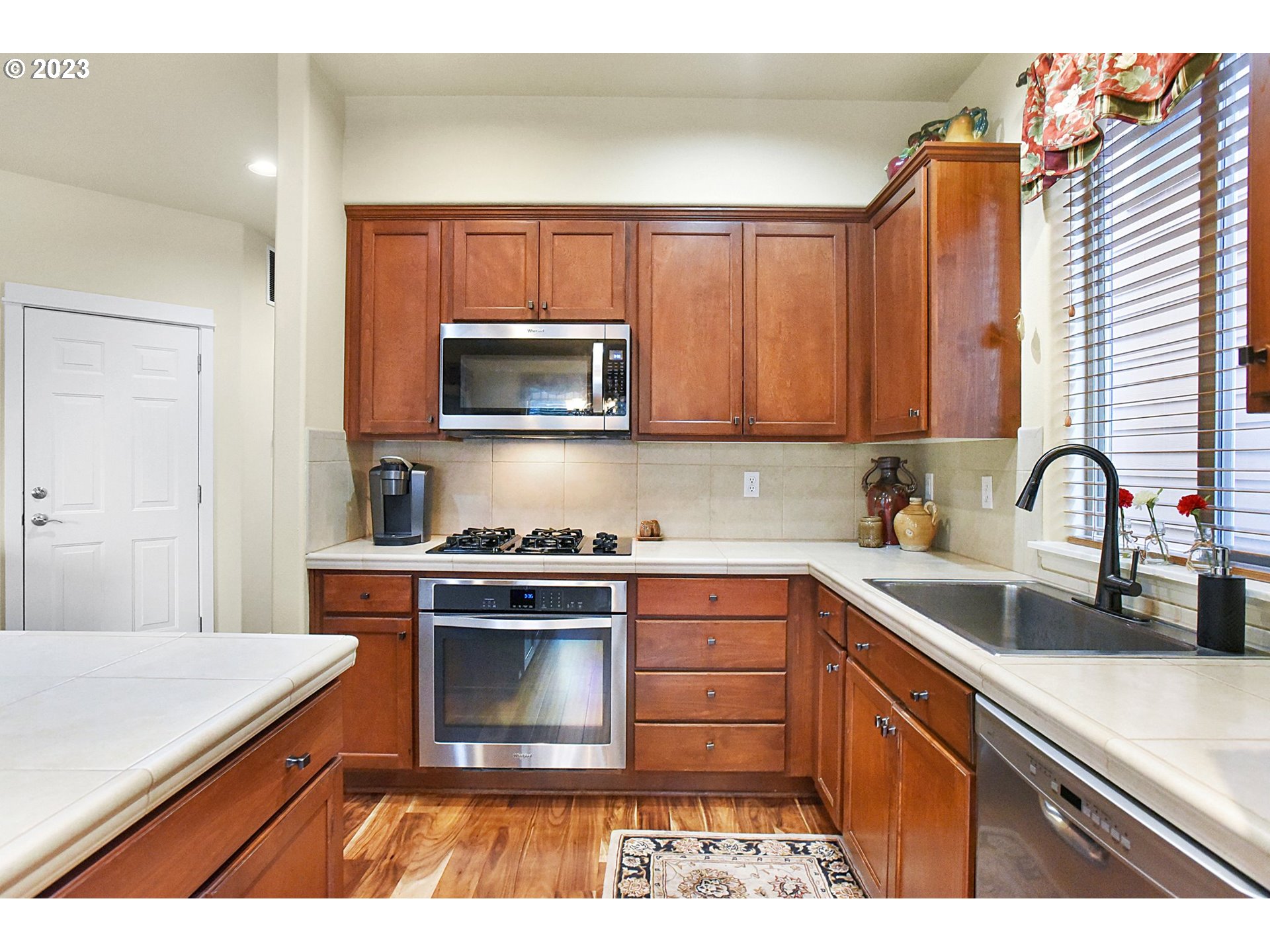 7826 Southwest Alder Street Tigard, OR 97224 - Photo 12 of 30 a kitchen with stainless steel appliances granite countertop a sink a stove a microwave and cabinets