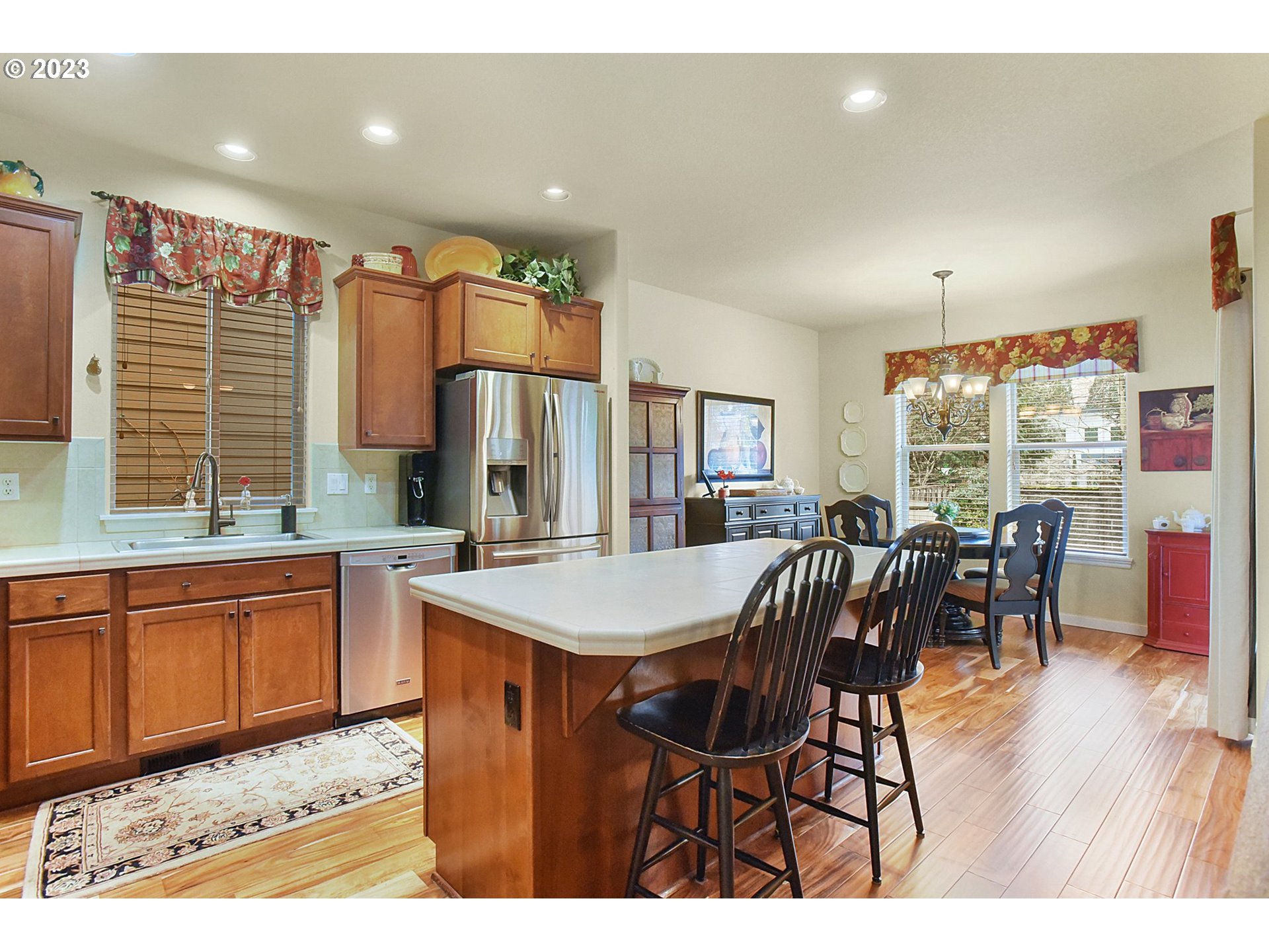 7826 Southwest Alder Street Tigard, OR 97224 - Photo 10 of 30 a open kitchen with stainless steel appliances granite countertop a dining table chairs and granite counter tops