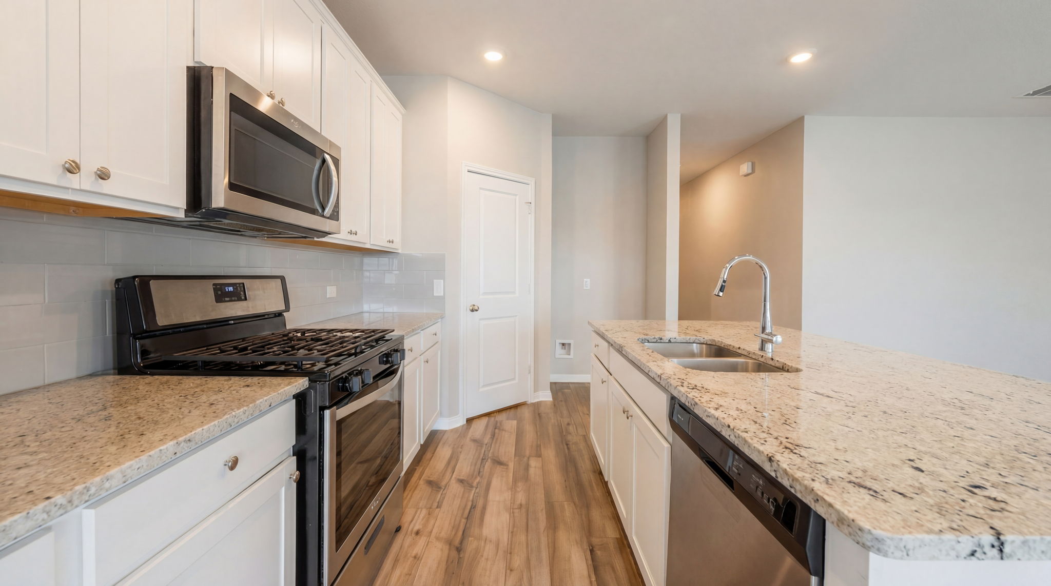 1003 Round Bale Road Hutto, TX 78634 - Photo 24 of 29 Kitchen featuring stainless steel appliances, light wood-type flooring, an island with sink, recessed lighting, and decorative backsplash