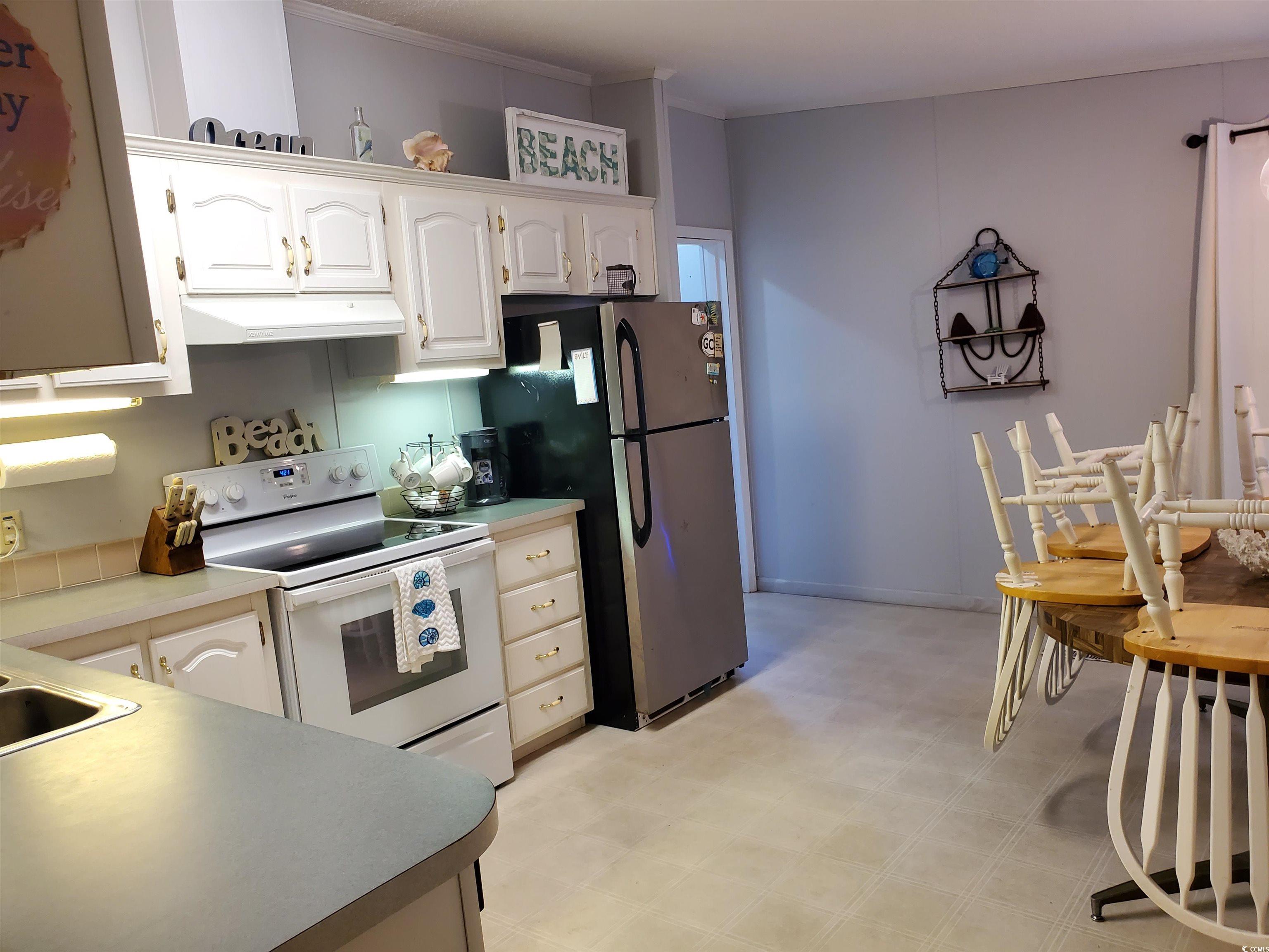 441 Delton Drive Murrells Inlet, SC 29576 - Photo 17 of 30 Kitchen featuring white electric stove, white cabinets, and stainless steel fridge