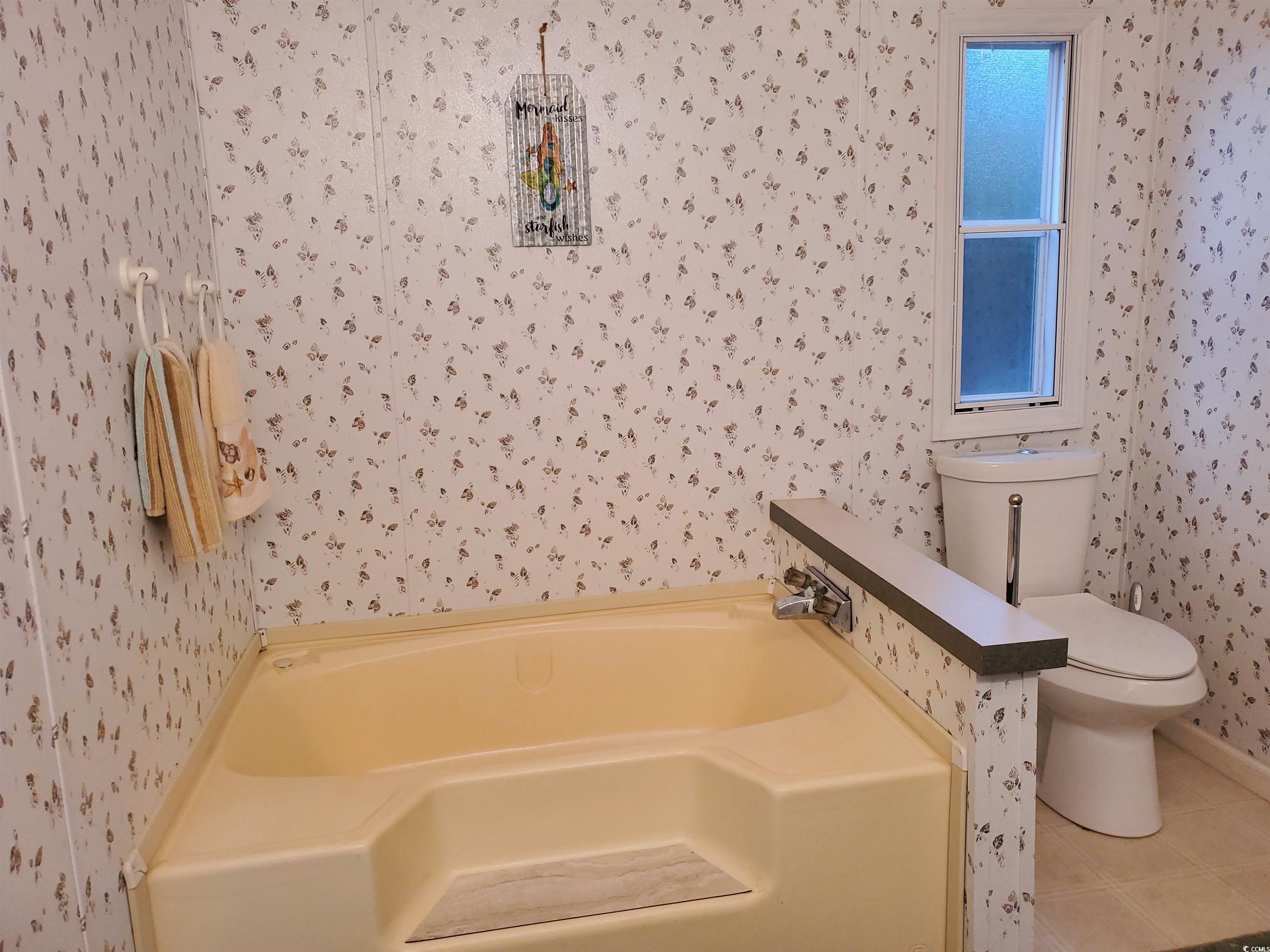 441 Delton Drive Murrells Inlet, SC 29576 - Photo 26 of 30 Bathroom featuring a tub to relax in, toilet, and tile patterned flooring