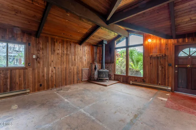 an empty room with furniture and floor to ceiling window