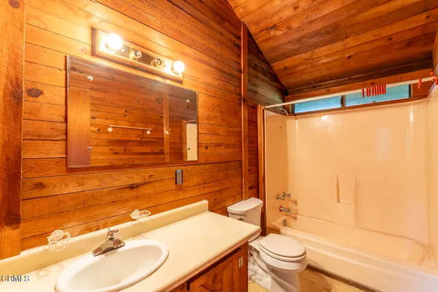 a bathroom with a sink and mirror with toilet