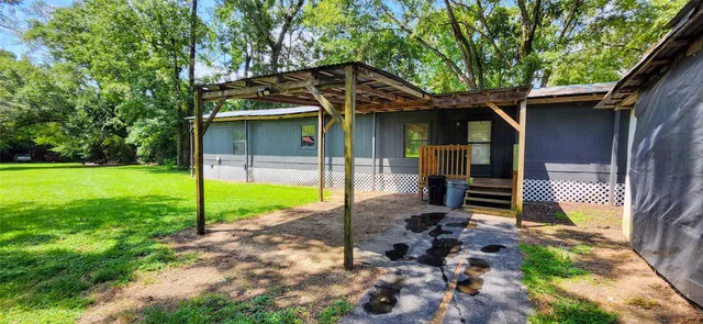 a view of a house with backyard and sitting area