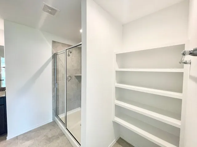 a bathroom with a shower and a glass door