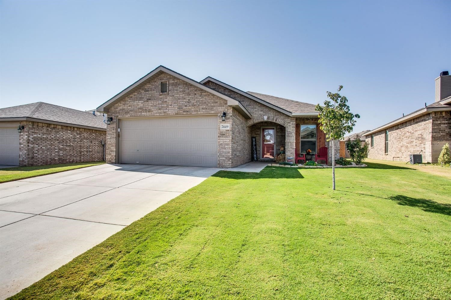 a front view of a house with garage and yard