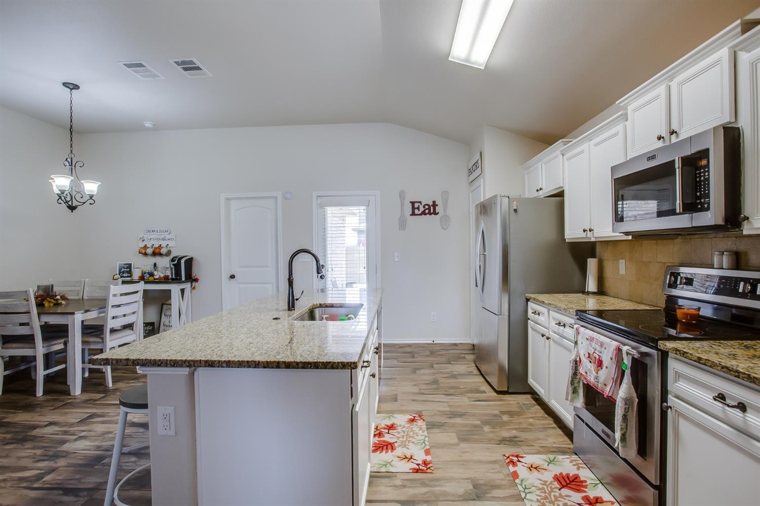 7449 104th Street Lubbock, TX 79424 - Photo 5 of 16 a kitchen with stainless steel appliances granite countertop a sink stove and refrigerator