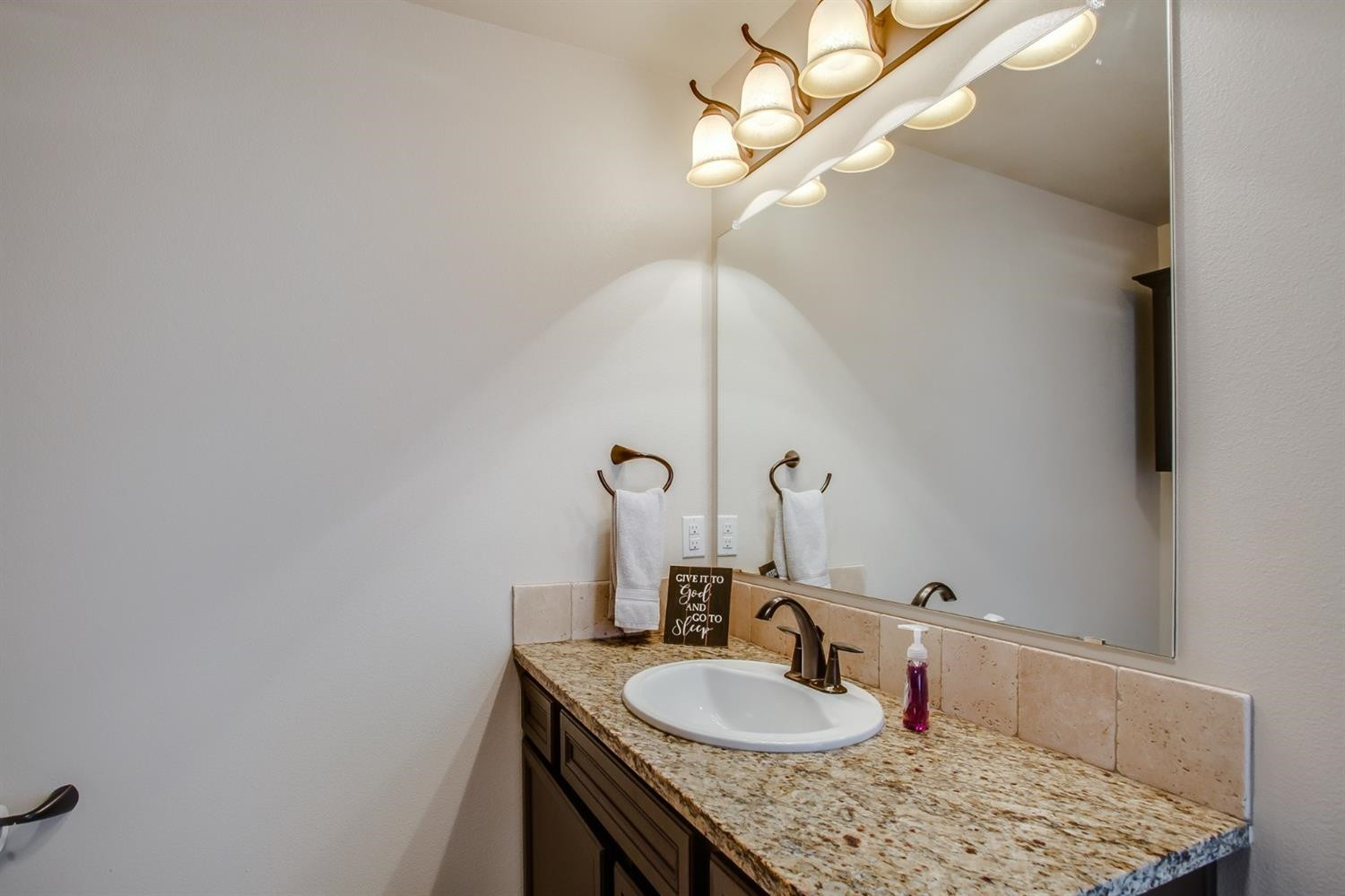 7449 104th Street Lubbock, TX 79424 - Photo 10 of 16 a bathroom with a sink and a mirror