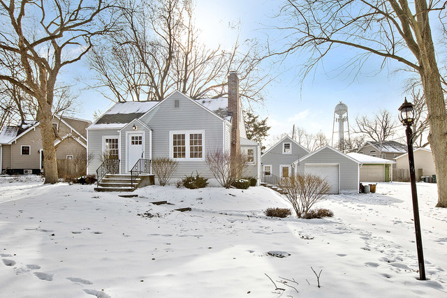 a front view of a house with a yard covered in snow
