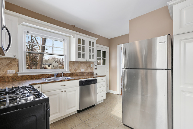 124 Village Road Willowbrook, IL 60527 - Photo 4 of 10 a kitchen with stainless steel appliances granite countertop a refrigerator sink and stove