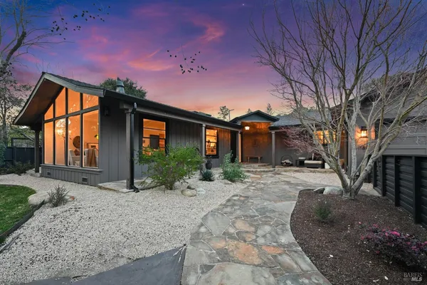 a front view of a house with a yard and outdoor seating