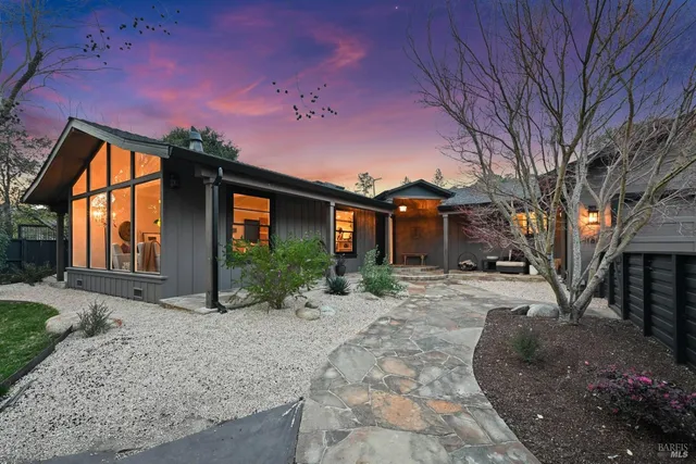 a front view of a house with a yard and outdoor seating