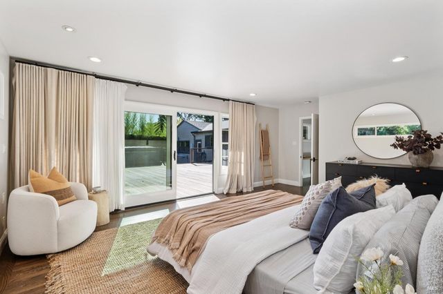 a spacious bedroom with a bed and glass window