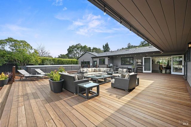 a view of roof deck with wooden floor and seating space
