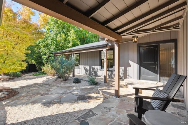 a view of a chair and table in backyard of the house