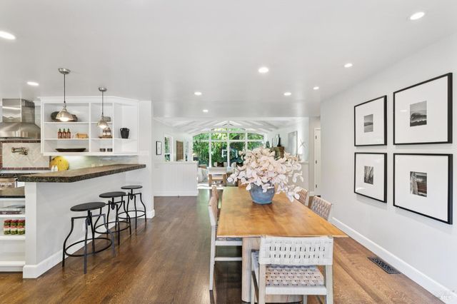 a kitchen with stainless steel appliances kitchen island granite countertop a table and chairs in it