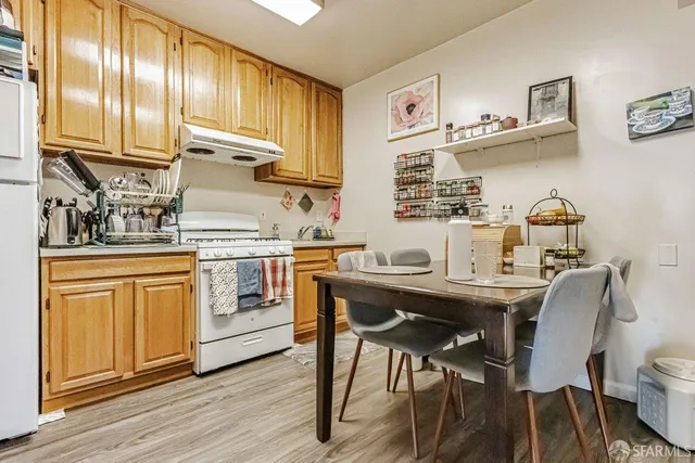 a kitchen with stainless steel appliances granite countertop a stove a sink dishwasher and cabinets with wooden floor