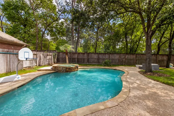 a view of a backyard with swimming pool and sitting area