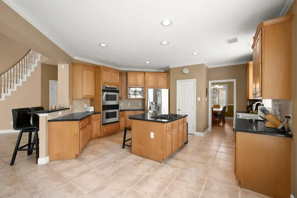 a large living room with stainless steel appliances kitchen island granite countertop a large counter top couches and chairs