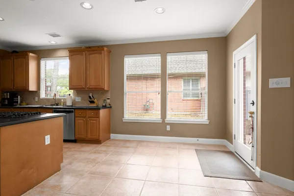 a open kitchen with granite countertop a sink window and cabinets