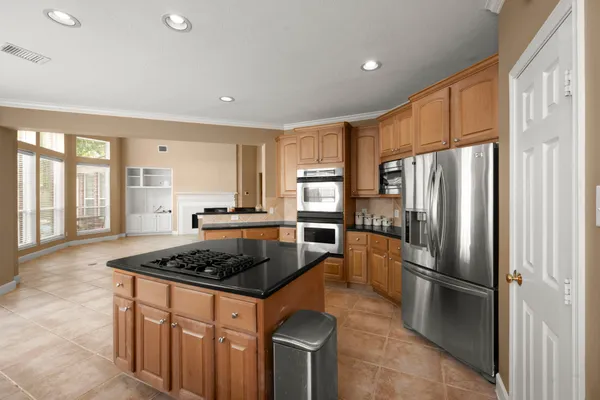 a kitchen with stainless steel appliances granite countertop a refrigerator stove and sink