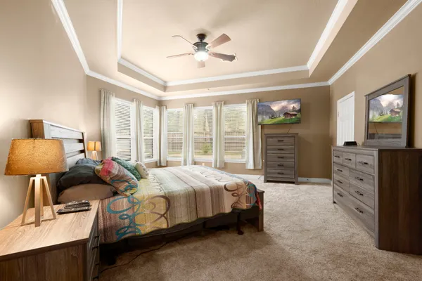 a spacious bedroom with a bed and wooden floor