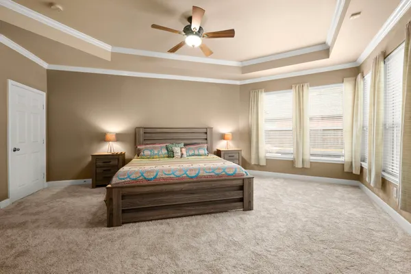 a bedroom with a bed and a ceiling fan