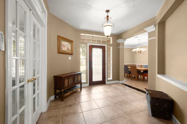 a view of a hallway with entryway and chandelier